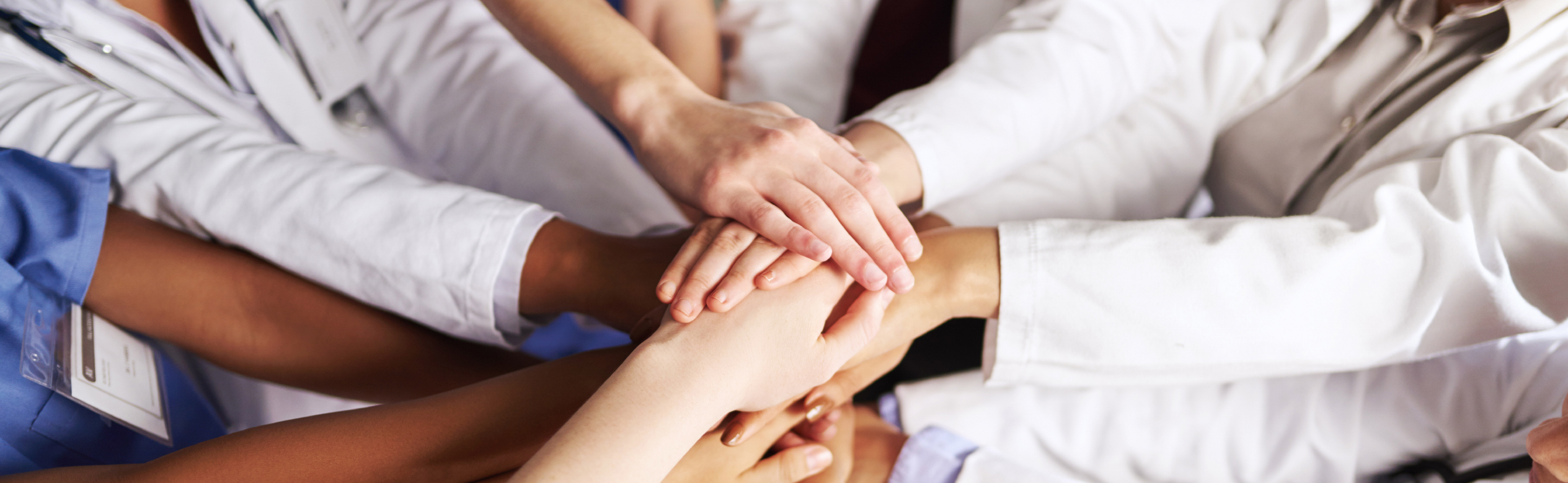 High angle shot of a group of medical practitioners joining their hands together in a huddle