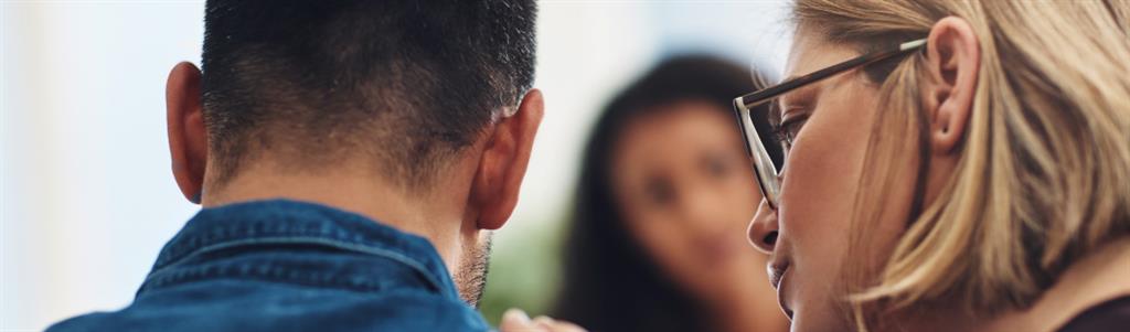 Wife is consoling her husband during a counsellin session with a therapist.